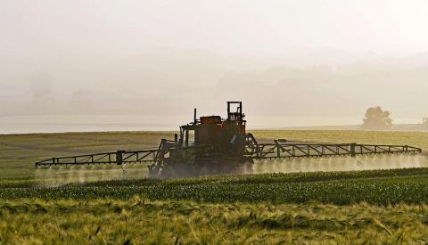 Tracteur répandant des pesticides dans un champ